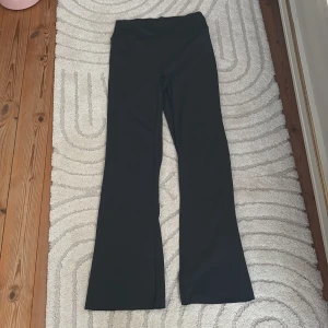Mörkgröna bootcut byxor från ICANIWILL - Mörkgröna bootcut byxor från ICANIWILL med hög midja och stretchigt material. Perfekta för en sportig och trendig look. Byxorna har en stilren design utan synliga detaljer och är bekväma att bära hela dagen.