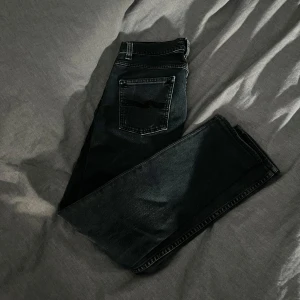 Nudie jeans - Säljer mörk blå Nudie jeans i slim fit W28 L30 det är i bra skick med liten defekt som du ser på sista bilden, men syns en när dom är på, säljs för 400kr