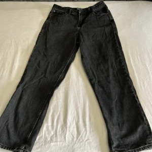 Svarta jeans från Jack & Jones - Klassiska svarta Relaxed Chris jeans från Jack & Jones med fem fickor och raka ben. Jeansen har normal passform och är tillverkade i denim med tydliga sömmar. Perfekta för en stilren och avslappnad look.