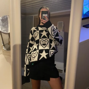 Svartvit stickad tröja med hjärt- och stjärnmönster - Säljer en cool svartvit stickad tröja med ett unikt mönster av hjärtan och stjärnor💋🤍