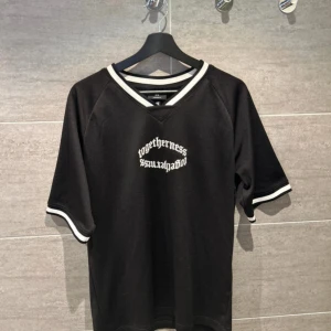 Svart t-shirt från H&M med tryck - Säljer en svart t-shirt från H&M med texten 'togetherness #soulajaboy' på bröstet. T-shirten har en oversized passform och vita ränder på ärmar och halsringning. Perfekt för en avslappnad stil.