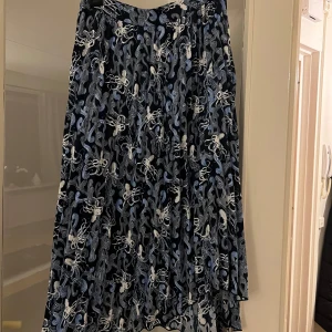 Mönstrad kjol från Carin Wester - Snygg kjol från Carin Wester med ett unikt bläckfiskmönster i blått och vitt. Kjolen har en flödande design som ger en härlig rörelse. 