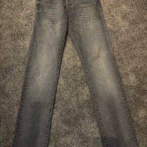 Jack & Jones slim Glenn - Snygga grå slim fit jeans från Jack & Jones, modell Glenn. Perfekta för en stilren look med klassisk femficksdesign och knappgylf. Passar bra till både vardag och mer uppklädda tillfällen. Storlek 28:30 i nytt skick 