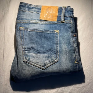 Blå jeans från K.O.I - Snygga blå jeans från K.O.I med klassiskt ljusa tvättade detaljer. Perfekta för en avslappnad stil. Märkespatch i läder baktill. Nypris: 1900kr Size: W32-L32. använda ett fåtal gånger så dom e i väldigt bra skick. Inga defekter. Priset inte hugget i sten!  Riktigt feta jeans. 