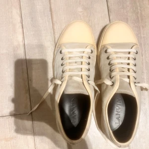 Lanvin skor - Ett par sköna beige sneakers från Lanvin med captoe. Tillverkade från Italien med en annorlunda design som passar för sticka ut lite. Skick 8/10 lite flaws på framsidan därav priset. Hör av vid intresse😄