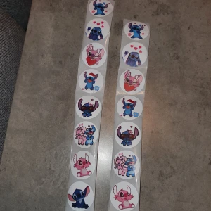 Stitch klistermärken - Två rader av runda klistermärken med stitch. Varje klistermärke har en unik design med hjärtan och olika poser. Perfekt för att dekorera anteckningsböcker eller brev, eller varför inte till pyssel. 