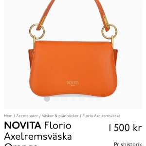 Orange axelremsväska från Novita - Snygg orange axelremsväska från Novita med stilrena detaljer i guld. Väskan har en justerbar axelrem och en praktisk storlek för vardagsbruk. Perfekt för att ge en färgklick till din outfit.