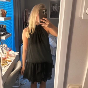 Svart halterneck klänning - Snygg svart halterneck klänning med volangdetaljer. Super söt och använd fåtal gånger, passar både xs och s 