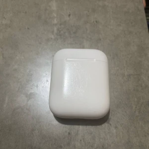 Trådlösa hörlurar med laddningsetui - Säljer ett par trådlösa hörlurar i vitt med tillhörande laddningsetui. Perfekt för musik och samtal på språng. Kompakt och lätt att bära med sig.