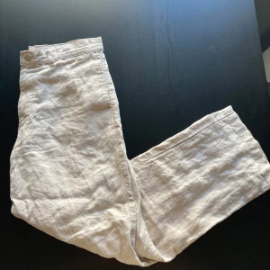 Giordano linnebyxor - Snygga beige linnebyxor från Giordano. Byxorna har en avslappnad passform med knapp och dragkedja i midjan. Perfekta för varma dagar med sitt lätta och luftiga material. Benen har förkortats lite hos en skräddare så passar perfekt för runt 1,80cm längden!