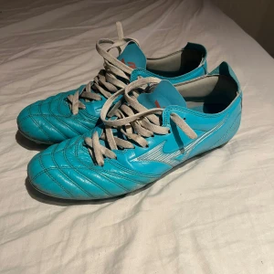 Mizuno fotbollsskor  - Säljer ett par blå mizuno fotbollsskor för orginal snörena har gått sönder och ersatt av ett par vanliga snören. Box medföljer med köpet!