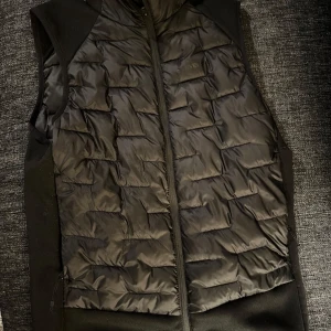 Väst - Snygg svart väst med dragkedja framtill. Perfekt för lager-på-lager under kyliga dagar