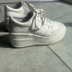 Vita sneakers med platåsula - Snygga vita sneakers med hög platåsula och snörning. Skorna har en unik sula med stjärnmönster och är perfekta för att ge lite extra höjd. Överlag ett väldigt fint skick!💗💗