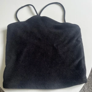 Svart ribbad linnetopp - Säljer en  svart ribbad linnetopp med smala axelband. 