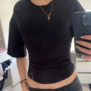 Svart tight topp - Säljer en svart tight topp med korta ärmar. Inte alls använd och helt nyköppt. 