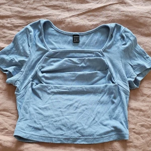 Ljusblå ribbad topp från Shein - Säljer en ljusblå ribbad topp från Shein. Toppen har korta ärmar och en fyrkantig halsringning. Perfekt för en avslappnad stil.