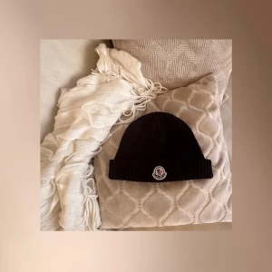 Svart ribbad mössa från Moncler - Svart ribbad mössa från Moncler med broderad logotyp framtill. Perfekt för att hålla värmen under kyliga dagar. Stilren design som passar till det mesta under de kyliga dagarna.  Nypris rätt  dyrt om du frågar mig:  betalade 3000kr utan frakt, säljes för endast 500kr & köparen står för frakten alltid: