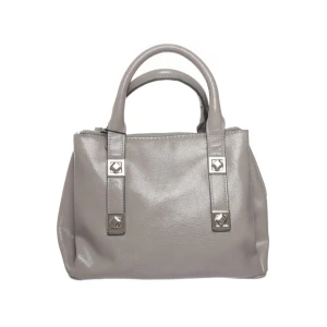 Grå handväska med silverdetaljer - Snygg grå handväska i skinn med två handtag och dekorativa silverdetaljer framtill. Väskan har en stilren och klassisk form, perfekt för att lyfta din outfit. 