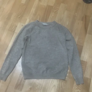 Beige stickad tröja från D.M.D - Säljer en enkel och stilren beige stickad tröja från D.M.D. Tröjan har rund halsringning, långa ärmar och ribbade muddar vid ärmslut och nederkant. Perfekt för lager-på-lager under kyliga dagar. Använd ett få tal gånger 