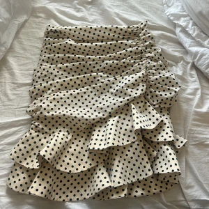 Prickig volangkjol från Zara - Supersöt kort kjol från Zara i beige med svarta prickar och flera volanger. 