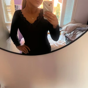 Intimissimi tröjan - Säljer en svart långärmad topp med v-ringning och fina spetsdetaljer vid halsringning och ärmslut. Toppens material är mjukt och stretchigt, vilket gör den bekväm att bära. Perfekt för dig som gillar stilrena plagg med det lilla extra. perfekt skick, använd ett par gånger. Nypris ca 50 €. 