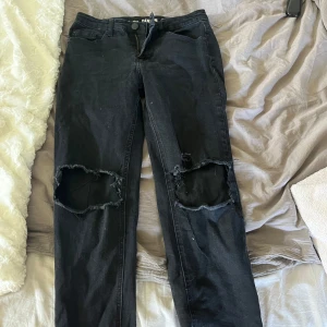 Svarta skinny jeans med hål - Jag har klippt hålen själv så dom kanske inte är perfekta har även klippt längst ner för att dom var för korta. vet inte exakt längd på dom nu men skriv privat för mått. vet inte vart jag köpt dom men jag tror på antingen lindex eller kappahl!