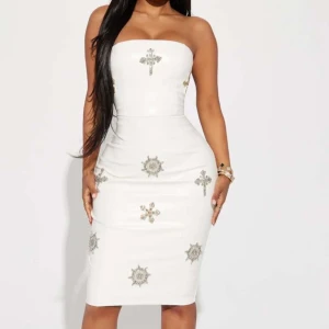 Vit axelbandslös klänning i skinnmatrial  - Klänning är använd endast i 2-3 timmar väldig fin och elegant, klänning är i skinnmatrial. Skicka ett meddelande så får ni fler bilder. 