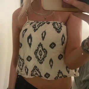 Mönstrad  linnetopp från Zara - Säljer en krämvit linnetopp från Zara med svart mönster. Toppen har tunna axelband, varav ett är knytbart. Perfekt för varma dagar och superfin med jeans eller kjol💞💞