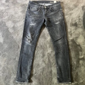 Dondup George destroyed jeans - Säljer ett par Dondup George grå/svarta destroyed jeans. Dessa e extremt populära och just denna modell är jättesvår att få tag på beggat. Byxorna har ett hål på knät, men det går snabbt att fixa genom att sätta en lapp bakom eller gå till skräddaren ifall man vill fylla i det. Förutom de är byxorna i 9-10 skick, det är byxorna på bilden. Fraktas samma dag. Hör av dig vid frågor!