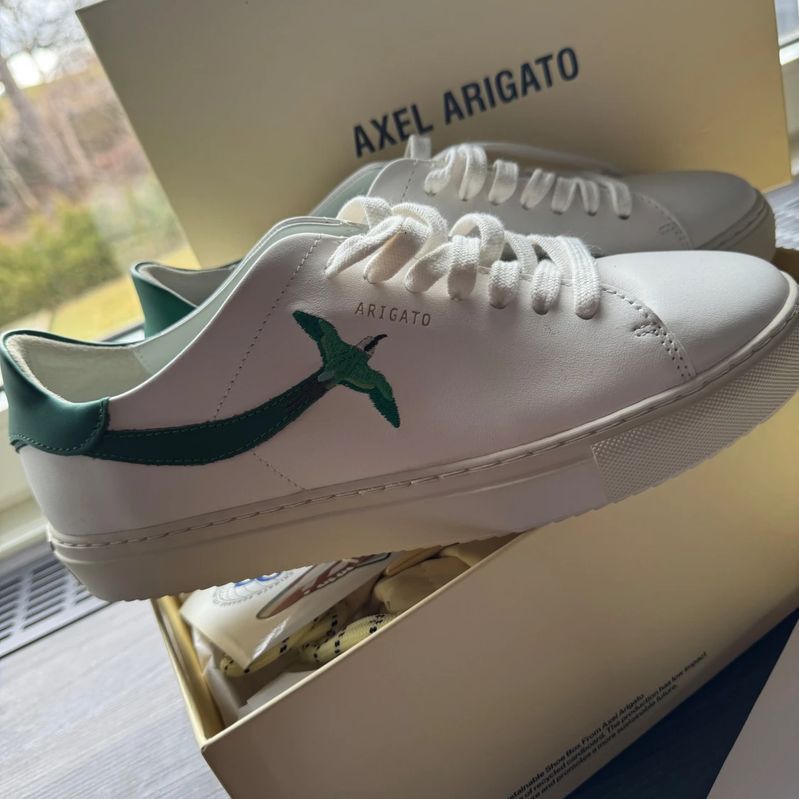 Vita sneakers från Axel Arigato med grön fågel - 1