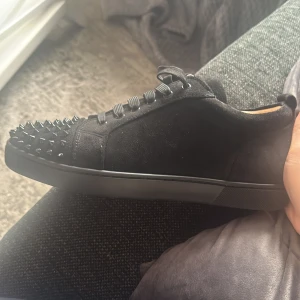 Svarta sneakers med nitar från Christian Louboutin - Säljer ett par svarta sneakers från Christian Louboutin kan även byta mot storlek 38,39 Skorna har snörning och är tillverkade i mocka för en lyxig känsla. Perfekta för dig som vill sticka ut priset kan diskuteras