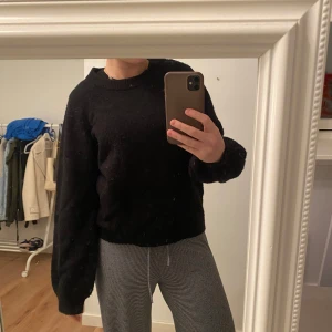 Svart stickad tröja - Säljer en mysig svart stickad tröja med långa puffärmar. Perfekt för kyliga dagar och enkel att matcha med olika outfits. Tröjan har en klassisk design med rund halsringning. Tröjan är från .Object