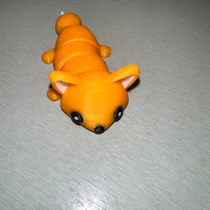 Orange 3D-printad leksaksräv - En söt orange 3D-printad leksaksräv med rörliga delar. Räven har stora svarta ögon och en vit svanstipp. Perfekt som dekoration eller leksak för barn.
