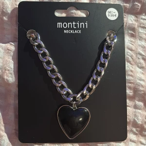Halsband med hjärta från Montini - Snyggt halsband från Montini med ett svart stort hjärta på.  Kostar ungefär 100kr men säljer för 90kr hör av dig💗