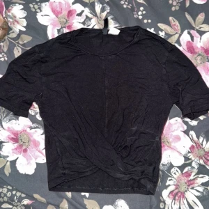 Svart kortärmad topp - Säljer en enkel svart kortärmad topp. Perfekt för en avslappnad stil. Toppen har en rund halsringning och är gjord i ett mjukt material.