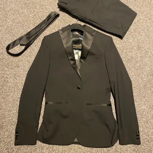 Kostym, med byxor och slips - Säljer denna Isaac dewhirst kostym med kostymbyxor och slips. Köpta för 1500 och använda en gång. Storlek är 44/XS. Hör av dig vid frågor!