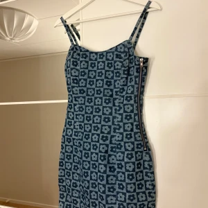 Blå blommig klänning med dragkedja - Fin blå jeans klänning med blommigt mönster och dragkedja på sidan. Hör av er vid funderingar eller om ni vill ha bilder med hur plagget sitter på mig. Titta gärna in mina andra plagg!