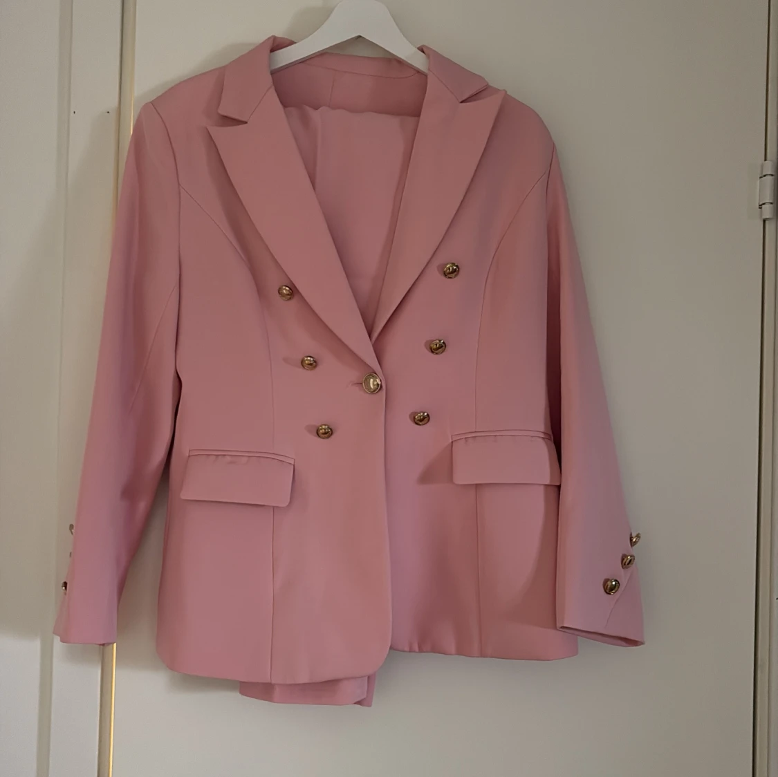 Rosa kavaj med guldknappar