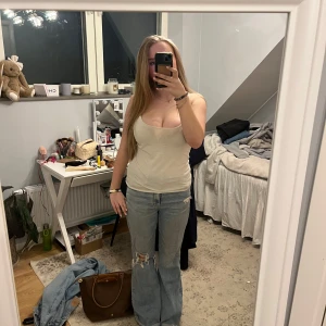 Jeans med hål - Säljer ett par jeans med ett hål vid knät. Jeansen är använda ett fåtal gånger men har inga tecken på användning. Jeansen är hög midjade men går att vika ner för en lågmidjad look. Jeansen är i en amerikans storlek 10 men passar mig som har 38 