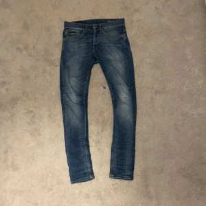 Blå jeansbyxor med orange sömmar - Säljer mina dondup Jeans i storlek 28