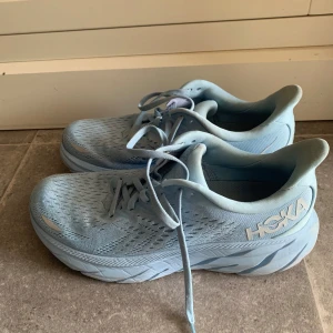 Ljusblå sneakers från Hoka - Superfina ljusblå löparskor från Hoka i storlek 40. Modellen heter Clifton 8 (dam). Använda en gång inomhus, men har tyvärr blivit lite missfärgade i plösen. Original förpackning medföljer. Köpta på stadium outlet för 900kr. Hör av dig vid frågor💕