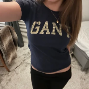 Mörkblå t-shirt från GANT - Snygg mörkblå t-shirt från GANT med stort tryck på bröstet. Perfekt för en avslappnad stil. Kortärmad och i mjukt material för extra komfort.