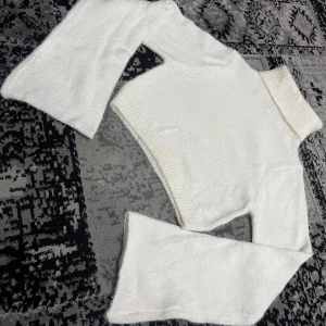 Vit stickad polotröja från Shein - Säljer en stilren vit stickad polotröja från Shein. Tröjan har en croppad design med långa ärmar och en hög polokrage. Perfekt för att hålla sig varm och trendig under kyligare dagar. Passar bra till både jeans och kjol.