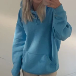 Blå hoodie - Säljer en mysig blå hoodie med känguruficka och justerbar huva. Perfekt för en avslappnad stil. Passar bra till både jeans och leggings.