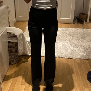 Svarta byxor från Bik Bok - Snygga svarta byxor från Bik Bok med hög midja och bootcut-stil. Perfekta för en stilren look. Byxorna har en dragkedja och knapp framtill för enkel påklädning. Är 173 cm för jämförelse 