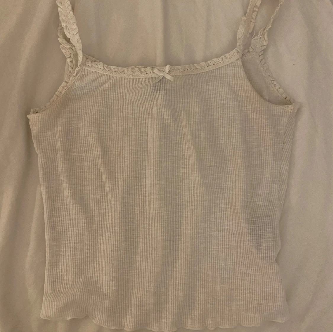 Vit ribbad linnetopp med spetsdetaljer