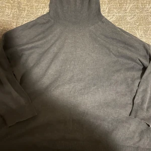 Ljusblå polotröja (Dam) - Säljer en stilren grå polotröja för damer. Tröjan har långa ärmar och en klassisk polokrage, perfekt för kyligare dagar. Den är tillverkad i ett mjukt material som ger en bekväm passform. Ett måste i garderoben för en enkel och elegant look. Storleken är XXL. Ordinarie pris - 800 SEK