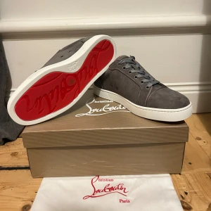  Christian Louboutin skor - Helt nya mocka Christian Louboutin skor med den ikoniska röda sulan. Skorna har snörning och en vit gummisula som ger en stilren look. Allt Og följer med och vid minsta fråga kom privat.