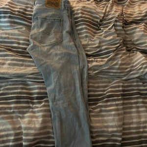 Ljusblå jeans från Replay - Snygga ljusblå jeans från Replay med klassisk femficksdesign och dragkedja. Perfekta för en avslappnad stil. Märkesdetaljer syns på baksidan.