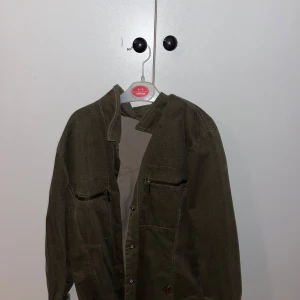 Olivgrön jacka från Golden Bridge - Säljer en olivgrön jacka från Golden Bridge. Jackan har långa ärmar och knappar framtill. Skriv för fler bilder